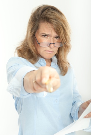 Woman with severe expression, holding a document and pointing at the cameraの写真素材