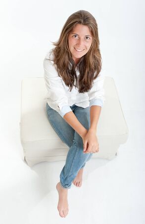 Pretty young brunette sitting on a stoolの写真素材