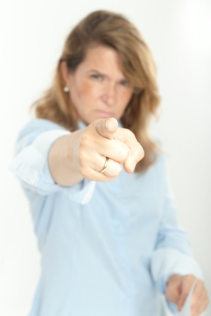 Woman with severe expression, holding a document and pointing at the cameraの写真素材