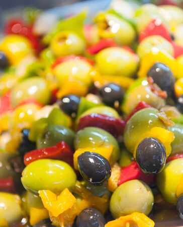A tray with tapas consisting of olives, anchovies and pickles on skewersの写真素材