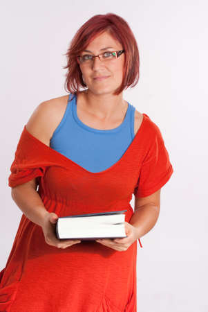 Red haired woman with glasses holding a bookの写真素材