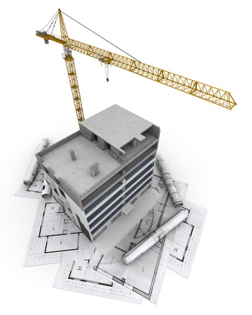 An apartment block in construction with a crane, on top of blueprintsの写真素材