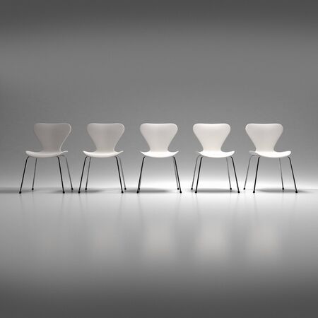 Row of five white plastic and metal chairs in a neutral backgroundの写真素材