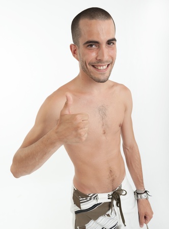Smiling man with thumbs up wearing swimming trunksの写真素材
