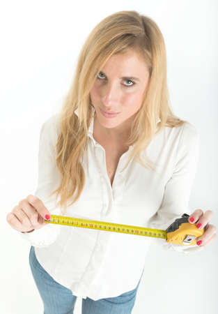 Woman holding a tape measure, suggesting home improvementの写真素材