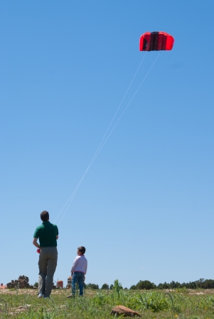 Man flying a kite in a sunny day with his sonの写真素材