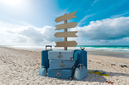 Pile of luggage and directional signs pointing everywhere in a tropical beachの写真素材