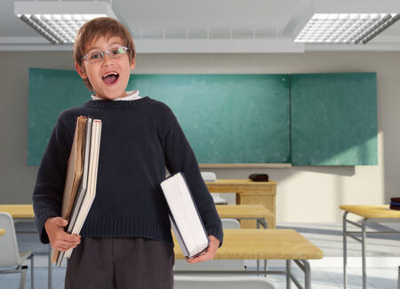Happy young boy with books in a classroom