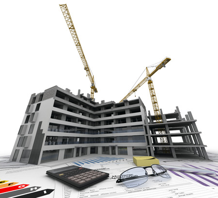 Building under construction with blueprints, bank forms, energetic efficiency charts, and a calculatorの写真素材