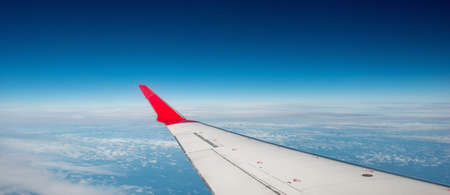 Cloudscape taken from a plane, with the aircraft wingの写真素材