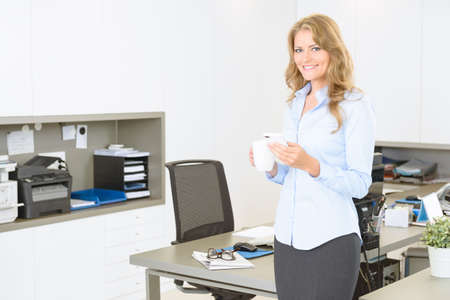 Businesswoman checking her cell phone in a coffee break