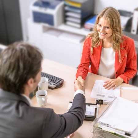 Male and female business people shaking handsの写真素材