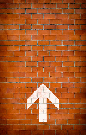 White arrow painted on brick wallの写真素材
