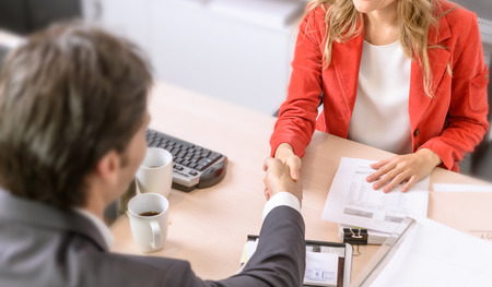 Male and female business people shaking handsの写真素材