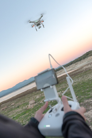 Man in a rural environment guiding a drone