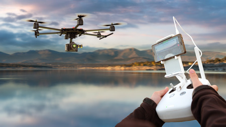 Hands guiding a drone through a remote control