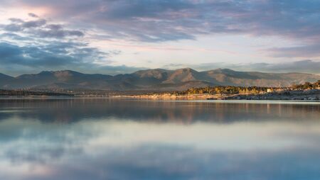 Lake surrounded by hills on an afternoon of early autumnの写真素材