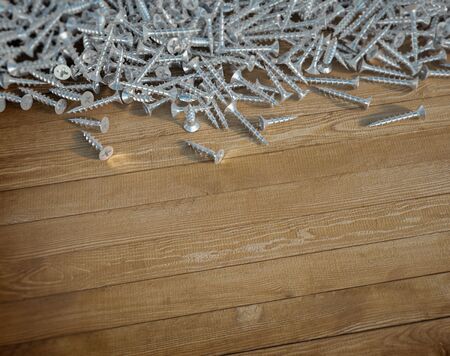 3D rendering of lots of screws and a wooden backgroundの写真素材