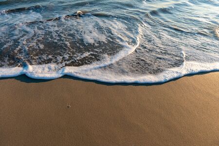 Wet beach sand and ocean tide