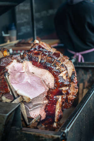Pork roasting on a spit on wood fireの写真素材