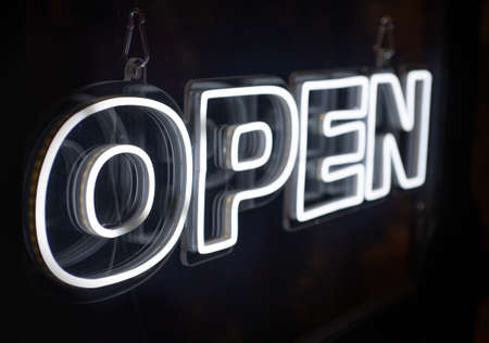 Open neon sign hanging on a window shopの写真素材
