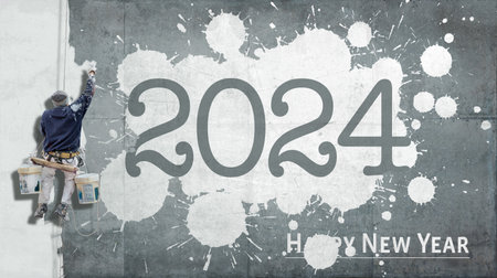 building painter hanging from harness painting a industrial wall with the words happy new year 2024の写真素材