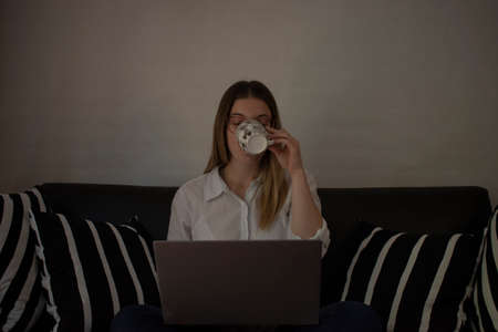 young girl with her dog doing home office in the sofaの写真素材