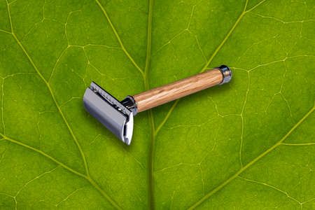 shaving razor with wooden handle with leaf in the backgroundの写真素材