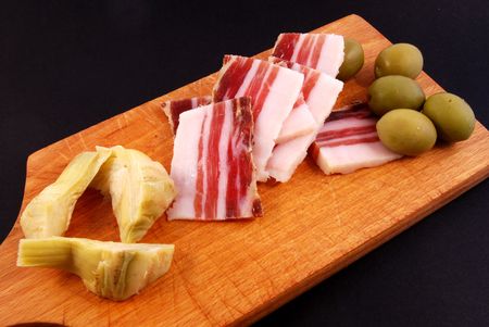 Bacon, green olives, artichoke hearts with black backgroundの写真素材