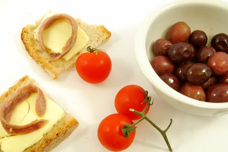 Bread and butter with anchovies and tomatoesの写真素材