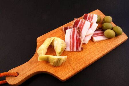 Now I prepare a nice toast with bacon, olives and artichokesの写真素材