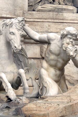 Triton blowing into the seashell, holding the horse in the Trevi Fountain in Rome          の写真素材