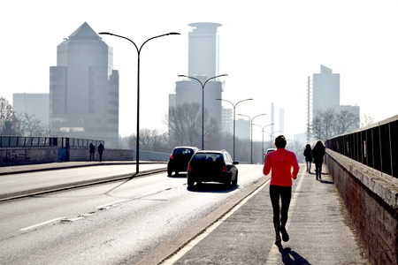 A woman is training along the way of a big cityの写真素材