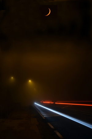 A dense fog on the streets of Brescia and above the fog the moon - Italyの写真素材