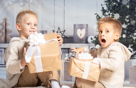 Twin children at home receiving and opening Christmas presents.の写真素材