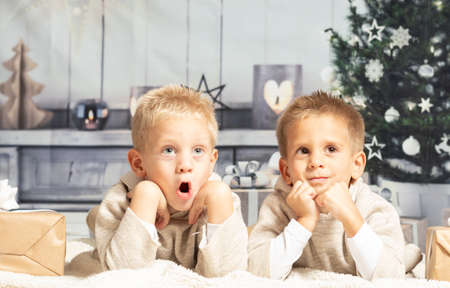 Twin boys lying at home at christmas parties
