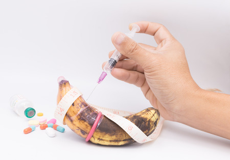 rotten banana in condom with hand injection,sexually transmitted disease conceptの写真素材