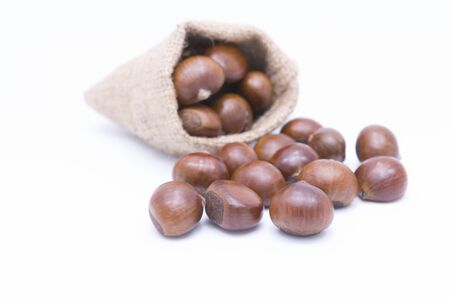 Fresh Chestnuts in yute isolated on whiteの写真素材