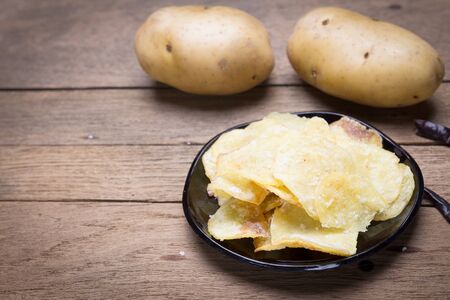 Potato chips heap on the black plateの写真素材