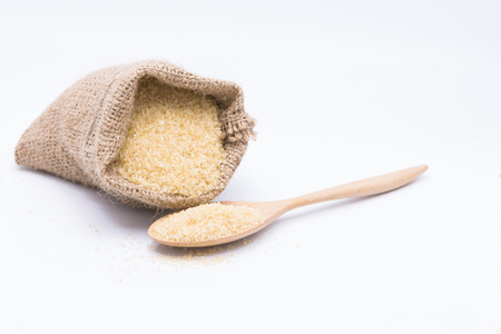 Close up brown Sugar in spoon  on sugarcane blur backgroundの写真素材