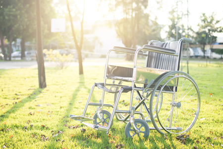 Empty wheelchair on the garden at sunset. Miracle concept. Healed person raised and went away or hope to healの写真素材