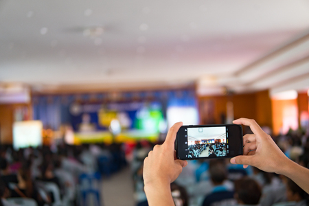 Soft focus,Mobile phone,cell phone held in hand showing finger touch on screen display.の写真素材