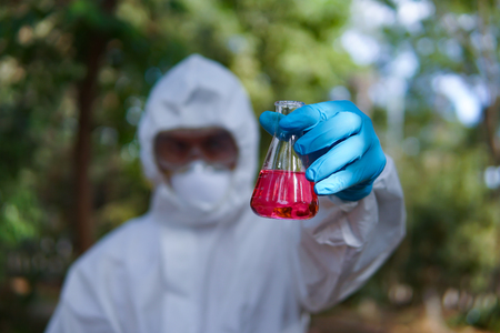 doctor or scientist in laboratory holding a syringe on grren natural bacground,selective focusの写真素材