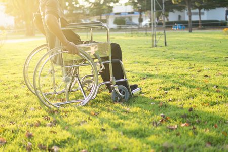 Disabled man on a wheelchair,focus on hand holding wheelの写真素材