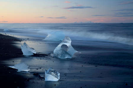 Glacier ice chunks on the black beach at Jokulsarlonの写真素材