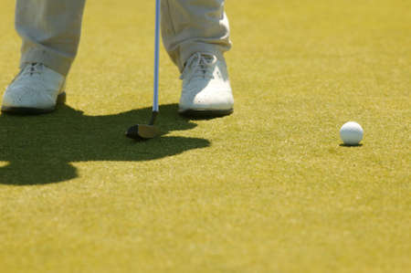 Zwei Füße, ein Golfball und ein Golfeisenの写真素材