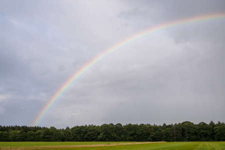 Bright and colorful rainbow over a Dutch fieldの写真素材