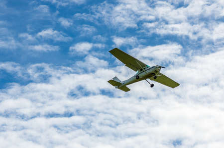 Single engine sport airplane in the air in front of cloudsの写真素材