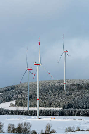 Wind turbines to generate electricity in the woods of the Sauerland region in winterの写真素材
