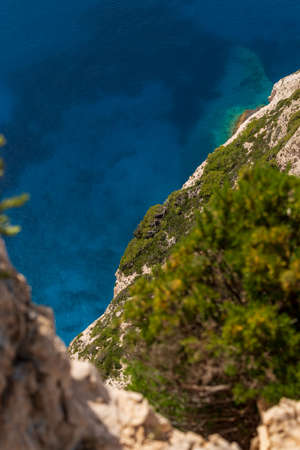 View over bush covered cliffs down to the deep blue Mediterranean Sea, selective focus, Zakynthos, Greeceの写真素材